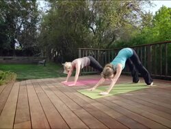 WS ZI ZO PAN Two women practising yoga on garden deck / Los Angeles, CA, United States Stock Footage