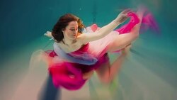 Caucasian woman in dress swimming under water Stock Footage