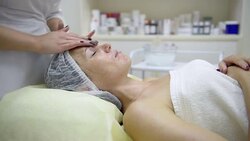 Beautician massaging the face of beautiful woman Stock Footage