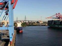 MS Shot of container ship on container terminal with Kohlbrand Bridge in harbour / Hamburg, Germany Stock Footage