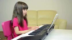 Young girl playing the piano Stock Footage