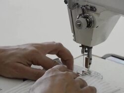 TS hands move material under sewing machine Stock Footage