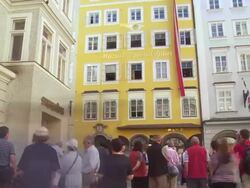 PAN TL Tourists in Front of the Birthplace of Wolfgang Amadeus Mozart in Salzburg Stock Footage