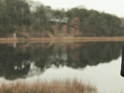 Mature woman by lake using binoculars Stock Footage