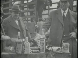 Men break bottles of liquor with hammers during Prohibition. News Clip