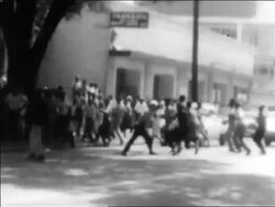 B/W 1963 Black protesters running across street by police at civil rights demonstration / Alabama Stock Footage