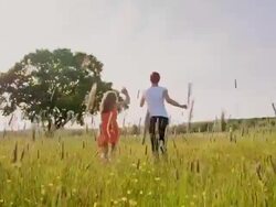 TS Mother and daughter skipping in the grass Stock Footage