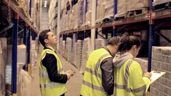 Supervisor and workers taking inventory in distribution warehouse Stock Footage