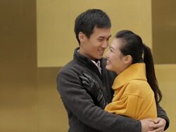 MS Young couple hugging and smiling against yellow wall / China Stock Footage