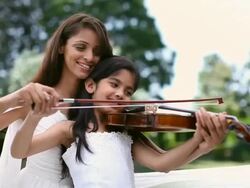 Girl learning violin with the help of her teacher  Stock Footage