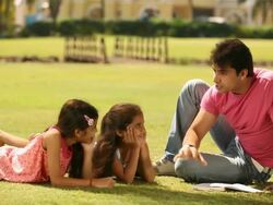Man telling stories to his daughters in a park Stock Footage