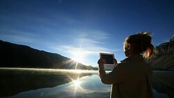 Woman using digital tablet to photograph lake Stock Footage