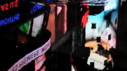A puddle reflects flashing billboards and passing pedestrians in Times Square. Stock Footage