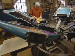 WS View of an artisian pulling ink over a silk screen to print designs on a shirt / Ann Arbor, Michigan, United States Stock Footage