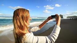 Young woman photographing landscape with mobile phone Stock Footage
