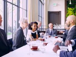 MS businessman handing business card to businessman in meeting at table in restaurant. Stock Footage