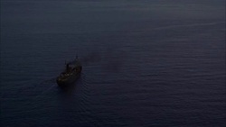 LOW AERIAL, New Zealand, Kapiti Coast, Freight ship in sea at dusk Stock Footage