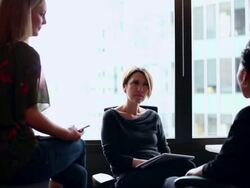 MS Two businessmen in discussion looking at digital tablet at workstation with coworkers/Washington, USA Stock Footage
