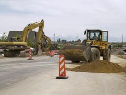 Static shot of a man holding a stop sign and a bulldozer. Stock Footage