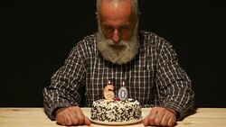 elderly man with sad look on the anniversary cake Stock Footage