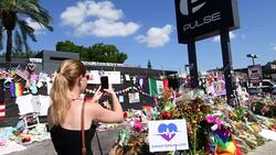 Orlando Florida Pulse night club tragedy shooting memorial at gay bar by terrorist on June 12, 2016, woman taking photos Stock Footage