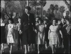 Teacher leads first grade class across the street Stock Footage