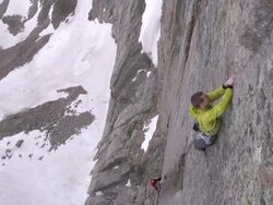 WS View of climber climbing big rock face with snow and lake below / Estes Park, Colorado, United States Stock Footage
