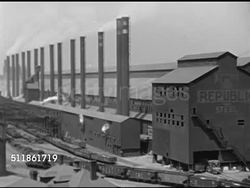 1946: USA FREIGHT RAILROAD: HA XWS Rail yard w/ parked cargo cars on tacks behind moving train FG, locomotive w/ black smoke. US STEEL: HA WS Steel Mill w/ ore carts moving on track, INT Foundry men pushing white hot metal shape, MS Scoring, slicing. Instructional Video