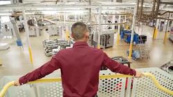 Supervisor on platform above factory floor Stock Footage