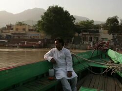 Man sitting on a boat at ganges river, Laxman Jhula, Rishikesh, Uttarakhand, India Stock Footage