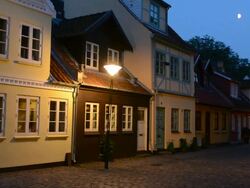 Odense beautiful old row homes cobblestone streets at twilight siunset night exposure in Hans Christian Andersen birthplace home Stock Footage