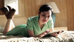 young woman lying on motel bed scans and types on tablet computer Stock Footage