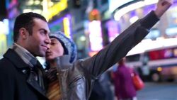 Young woman takes smartphone photo kissing boyfriend on cheek in Times Square Stock Footage