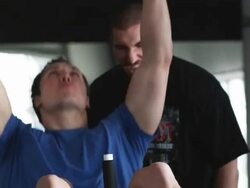 trainer helping a male client do sit ups with dumbbells Stock Footage