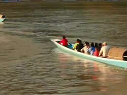 MS TS Shot of wooden canoe with passengers moving away on mekong river / Luang Prabang, Laos Stock Footage