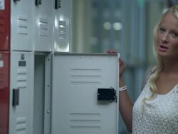 Slow motion upward pan of teenage girl missing part of left arm at her locker. Stock Footage
