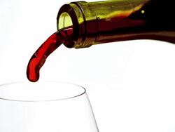 ECU SLO MO Red wine pouring into glass against white background / Vieux Pont, Normandy, France Stock Footage
