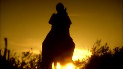 King Arthur in silhouette on horseback drawing sword with sun behind Stock Footage