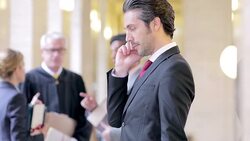 Lawyer talking on cell phone in courthouse hallway Stock Footage