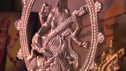 A Lakshmi painting leans behind a Saraswati sculpture at a gift shop in India. Stock Footage