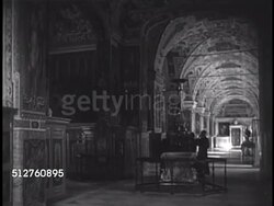 1940: VATICAN CITY MUSEUMS (Musei Vaticani): EXT Museum. INT Gallerys of museum, TU/TD Row of paintings hanging on ceiling above gallery arches. Unidentified bust on pedestal in gallery. Instructional Video