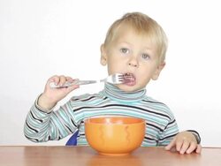 little boy eats with a fork Stock Footage