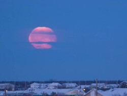 WS T/L View of full moon setting over downtown covering with snow / Yellowknife, Northwest Territories, Canada Stock Footage