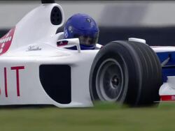 Low angle close up driver of Formula One race car steering around S curve Stock Footage