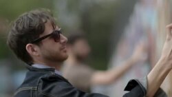 Young graffiti artists cover urban wall with spray paint Stock Footage