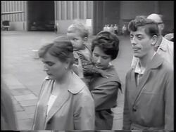 B/W 1961 couple with small child in line outdoors / East German refugees / beginning of Berlin Wall Stock Footage