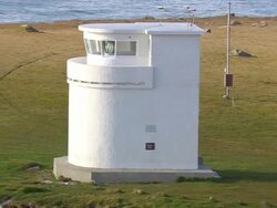 MS AERIAL ZO View of people roaming at Latrabjarg Lighthouse and peninsula / Iceland Stock Footage