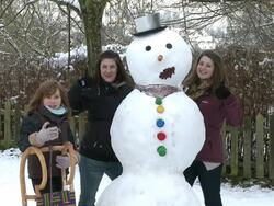 MS Women standing next to snowman after making / Saarburg, Rhineland-Palatinate, Germany Stock Footage