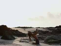 MS Rasta man practicing  yoga posture on beach while spinning poi balls / Montezuma, Punteranes, Costa Rica Stock Footage