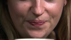 Woman slurping coffee from a cup News Clip